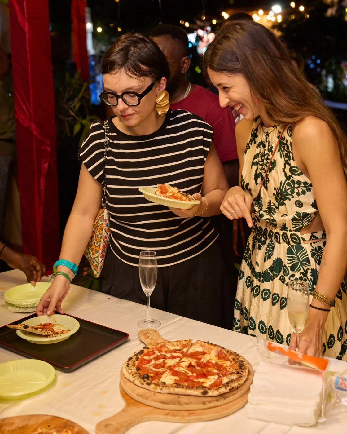 Guests enjoying pizza with champagne