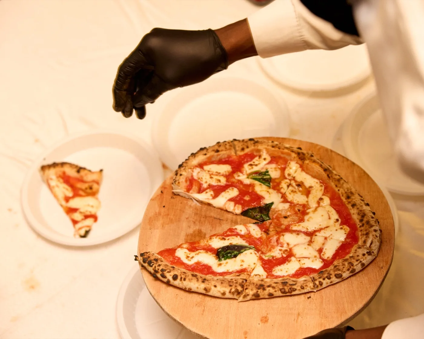 Pizza being sliced on wooden board
